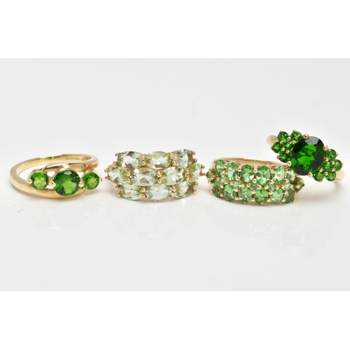 82 - FOUR 9CT GOLD GEMSET RINGS, to include a three stone ring, assessed as circular cut diopside, prong ... 