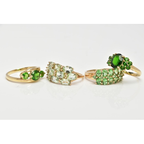 82 - FOUR 9CT GOLD GEMSET RINGS, to include a three stone ring, assessed as circular cut diopside, prong ... 