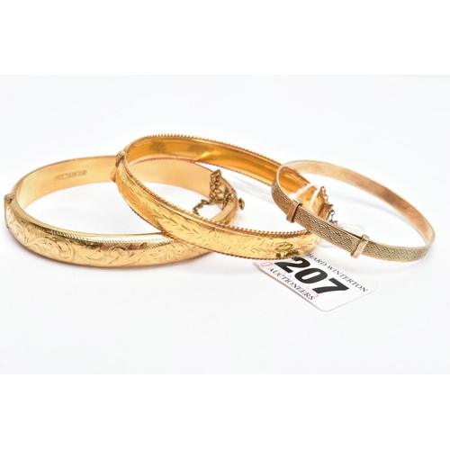 207 - THREE YELLOW METAL BRACELETS, a floral hinged bangle with a rope twist edge, fitted with a push pin ... 