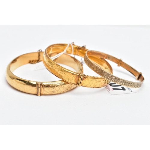 207 - THREE YELLOW METAL BRACELETS, a floral hinged bangle with a rope twist edge, fitted with a push pin ... 