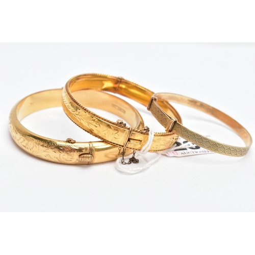 207 - THREE YELLOW METAL BRACELETS, a floral hinged bangle with a rope twist edge, fitted with a push pin ... 