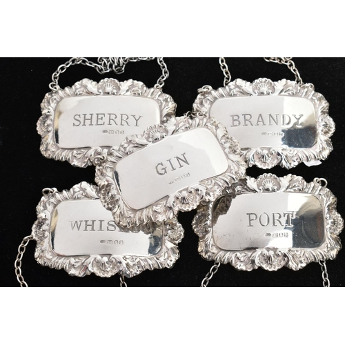 221 - FIVE SILVER DECANTER LABELS, each of a rectangular form with decorative floral and scroll rims, labe... 