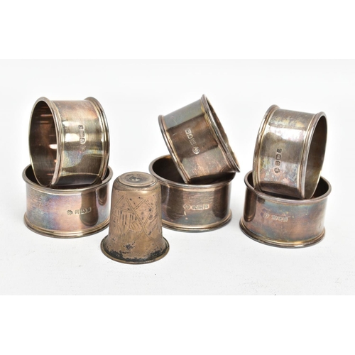 229 - SIX SILVER NAPKIN RINGS AND A WHITE METAL CUP, each napkin ring of a circular form, plain polished d... 