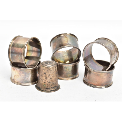 229 - SIX SILVER NAPKIN RINGS AND A WHITE METAL CUP, each napkin ring of a circular form, plain polished d... 