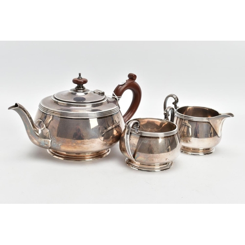 233 - A THREE PIECE SILVER TEA SET, to include a silver round teapot with a brown insulated handle, detail... 