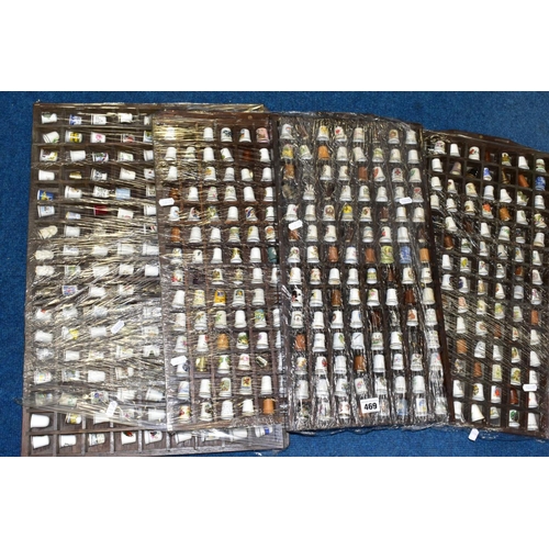 469 - FOUR DISPLAY TRAYS CONTAINING APPROXIMATELY FIVE HUNDRED AND TEN THIMBLES, mainly ceramic thimbles, ... 