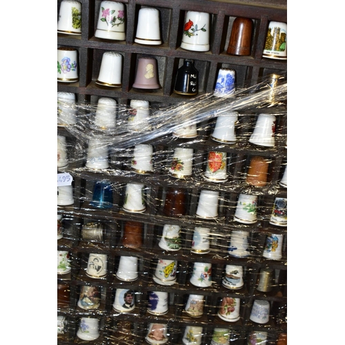 469 - FOUR DISPLAY TRAYS CONTAINING APPROXIMATELY FIVE HUNDRED AND TEN THIMBLES, mainly ceramic thimbles, ... 