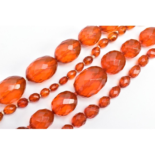 60 - TWO SETS OF ORANGE FACETED PLASTIC BEAD NECKLACES, each designed with graduated, faceted oval beads,... 