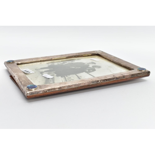 100 - AN ARTS AND CRAFTS SILVER PHOTO FRAME, AF of a rectangular form, plain polished design with three co... 