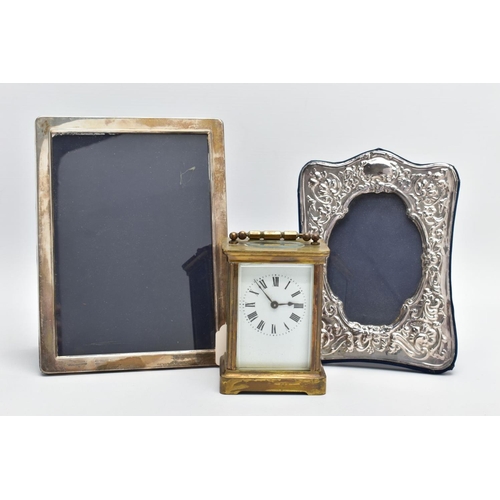 103 - TWO SILVER PHOTO FRAMES AND A CARRIAGE CLOCK, the first frame featuring a floral design and an oval ... 