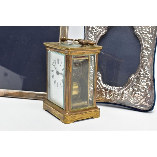 103 - TWO SILVER PHOTO FRAMES AND A CARRIAGE CLOCK, the first frame featuring a floral design and an oval ... 