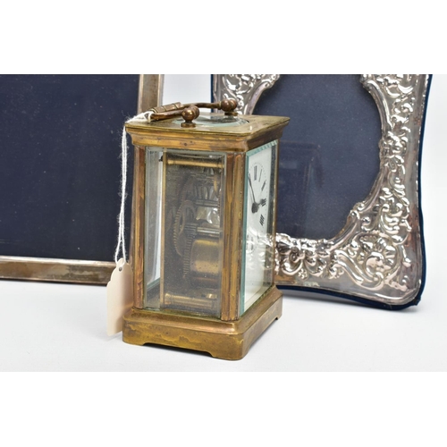 103 - TWO SILVER PHOTO FRAMES AND A CARRIAGE CLOCK, the first frame featuring a floral design and an oval ... 