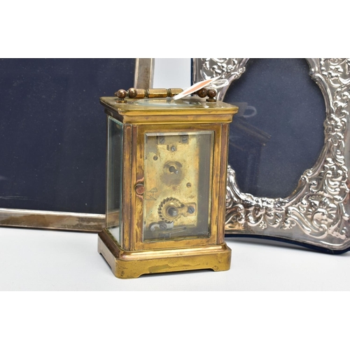 103 - TWO SILVER PHOTO FRAMES AND A CARRIAGE CLOCK, the first frame featuring a floral design and an oval ... 