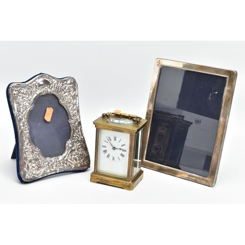 103 - TWO SILVER PHOTO FRAMES AND A CARRIAGE CLOCK, the first frame featuring a floral design and an oval ... 