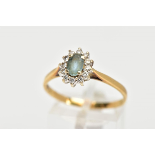 146 - AN 18CT GOLD GEM SET CLUSTER RING, of an oval form, centring on an oval cut aquamarine, within a sur... 