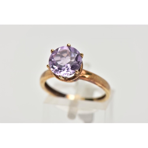 156 - A AMETHYST SOLITAIRE RING, a circular cut amethyst, approximate diameter 9mm, set in a yellow metal ... 