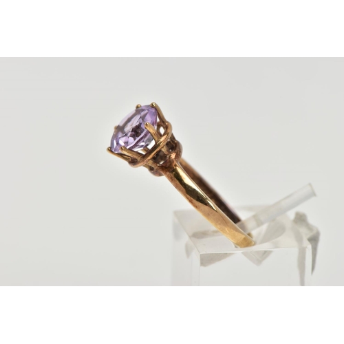 156 - A AMETHYST SOLITAIRE RING, a circular cut amethyst, approximate diameter 9mm, set in a yellow metal ... 