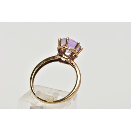 156 - A AMETHYST SOLITAIRE RING, a circular cut amethyst, approximate diameter 9mm, set in a yellow metal ... 