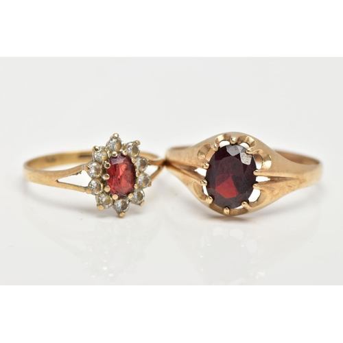 16 - TWO 9CT GOLD GARNET RINGS, the first of an oval design set with an oval cut garnet within a ten claw... 