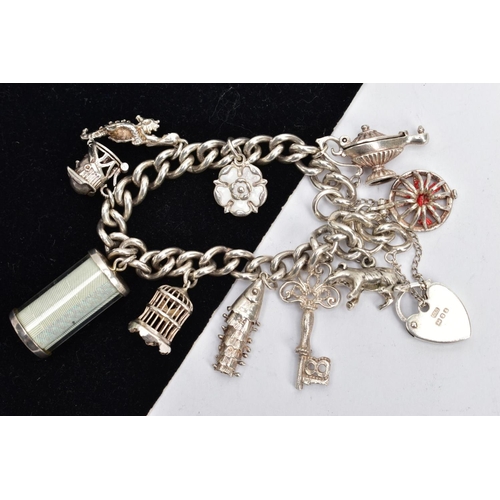 175 - A SILVER CHARM BRACELET AND CHARMS, a curb link bracelet fitted with and engraved heart padlock clas... 