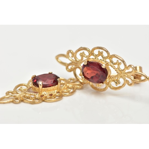 19 - A PAIR OF GARNET EARRINGS, a pair of yellow metal filigree designed drop earrings, set with an oval ... 