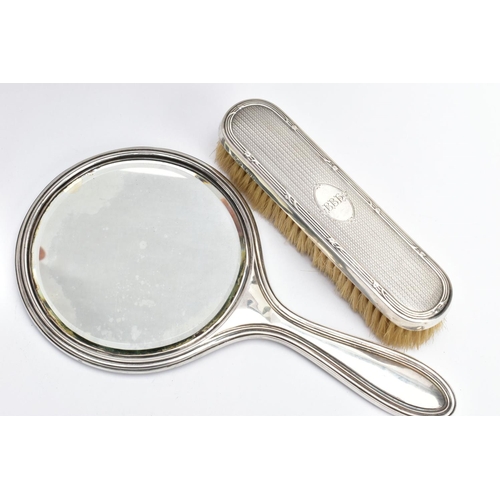 192 - A SILVER VANITY MIRROR AND CLOTHES BRUSH, the mirror of a round form, engine turned design and engra... 