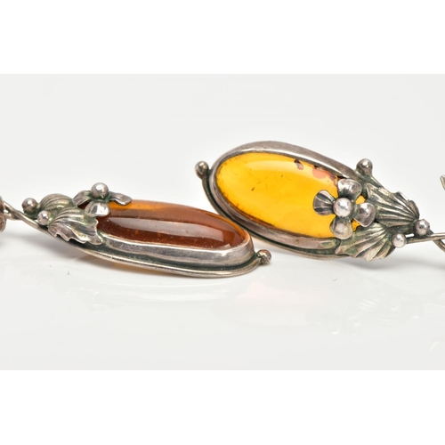 20 - A PAIR OF SILVER AND AMBER EARRINGS, elongated oval amber set into floral and foliage silver mounts,... 