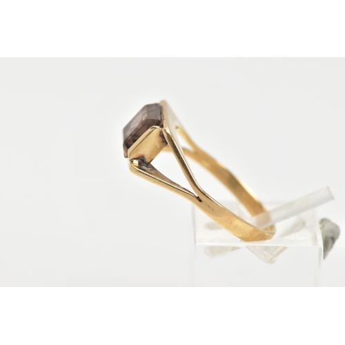 24 - A SMOKEY QUARTZ DRESS RING, rectangular cut Smokey quartz stone, set in a yellow metal bezel setting... 