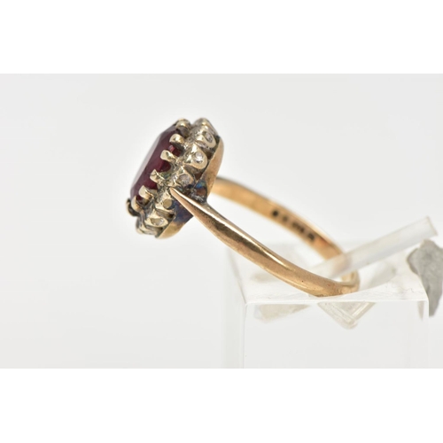 25 - A GARNET AND DIAMOND CLUSTER RING, an oval cut almandine garnet surrounded with a halo of round bril... 