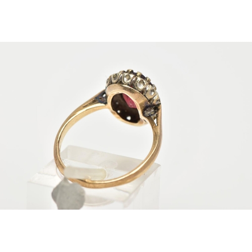 25 - A GARNET AND DIAMOND CLUSTER RING, an oval cut almandine garnet surrounded with a halo of round bril... 