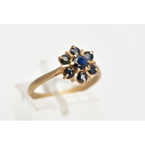 27 - A 9CT GOLD SAPPHIRE CLUSTER RING, seven circular cut sapphires prong set in a floral design, leading... 