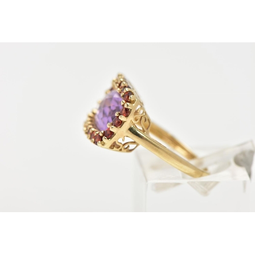 29 - AN AMETHYST AND GARNET DRESS RING, a fancy cut amethyst set with a halo of circular cut garnet stone... 