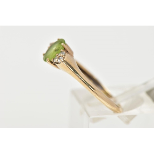 31 - A 9CT GOLD PERIDOT RING, an oval cut peridot, accented with six circular cut cubic zirconia, in a ye... 