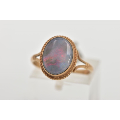 32 - A 9CT GOLD OPAL RING, of an oval design, set with an opal cabochon, displaying blue and red play of ... 