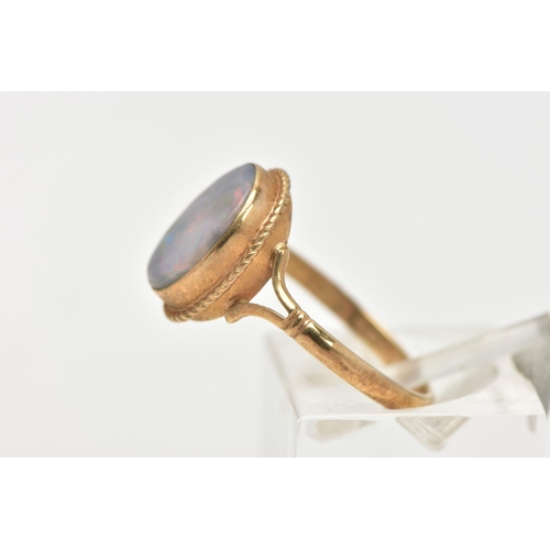 32 - A 9CT GOLD OPAL RING, of an oval design, set with an opal cabochon, displaying blue and red play of ... 