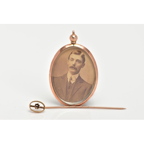 54 - A DOUBLE SIDED PHOTO LOCKET AND A STICK PIN, the photo locket of an oval form, inserted with a photo... 