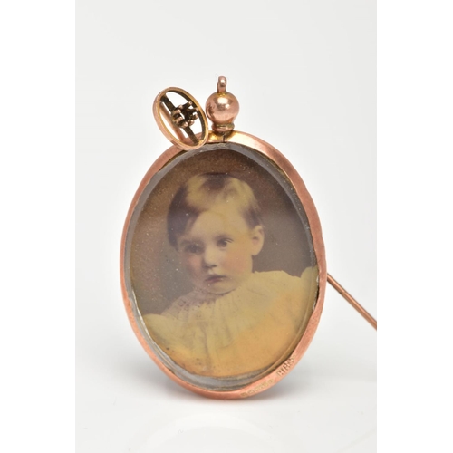 54 - A DOUBLE SIDED PHOTO LOCKET AND A STICK PIN, the photo locket of an oval form, inserted with a photo... 