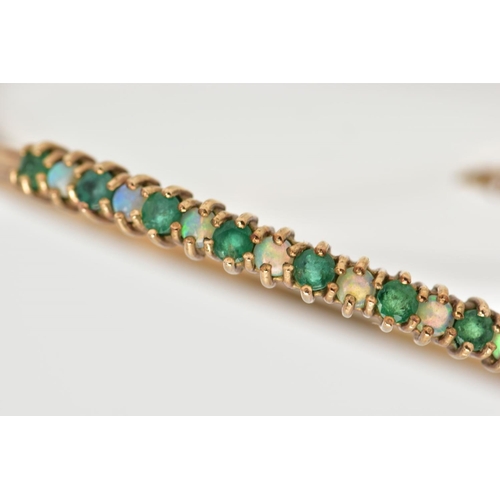 60 - A 9CT GOLD EMERALD AND OPAL BANGLE, hinged bangle, designed with a row of circular cut emeralds inte... 