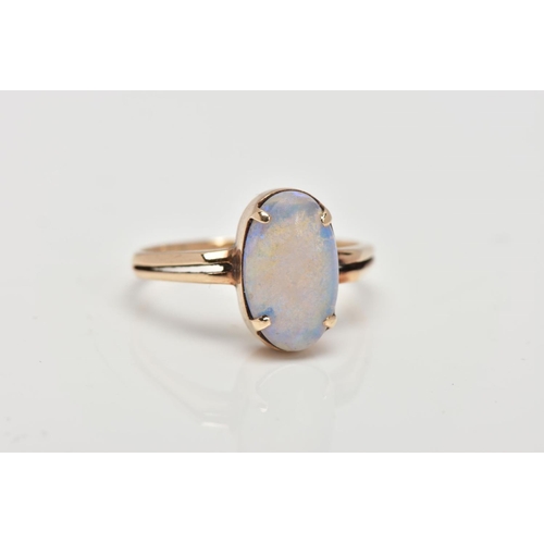 62 - A YELLOW METAL OPAL RING, designed with a four claw set oval opal cabochon, bifurcated shoulders lea... 