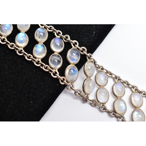 66 - A WHITE METAL MOONSTONE BRACELET, designed with two rows of oval cabochon moonstones each collet mou... 