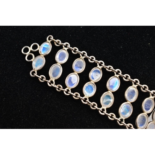 66 - A WHITE METAL MOONSTONE BRACELET, designed with two rows of oval cabochon moonstones each collet mou... 