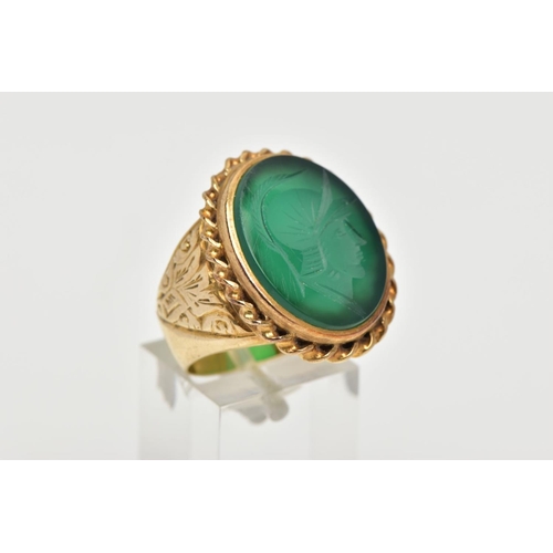 72 - A GENTS 9CT GOLD INTAGLIO RING, of an oval form, engraved soldiers head within a green chalcedony, c... 