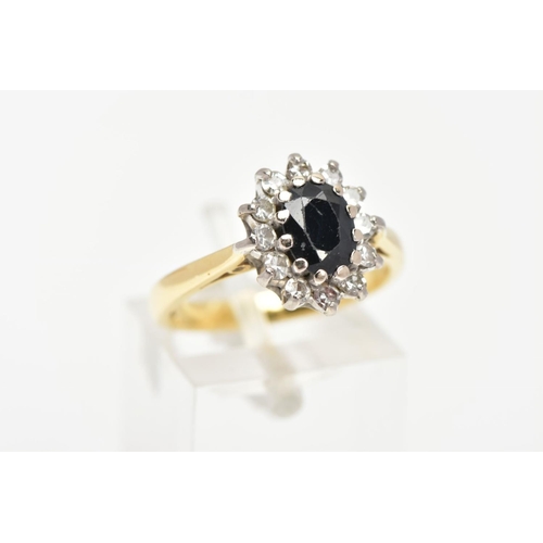 77 - A SAPPHIRE AND DIAMOND CLUSTER RING, a blue oval sapphire prong set with twelve round brilliant cut ... 