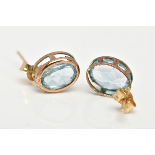 28 - A PAIR OF GEM SET EARRINGS, oval cut blue stones assessed at topaz set in a yellow metal basket sett... 