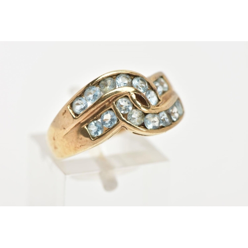 37 - AN AQUAMARINE DRESS RING, sixteen circular cut aquamarine stones channel set in a double row cross o... 