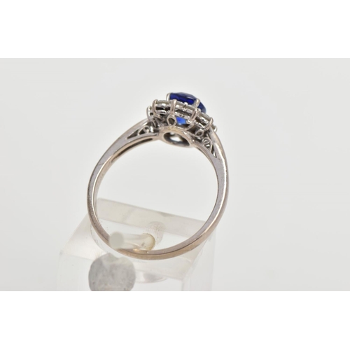 48 - A SAPPHIRE AND DIAMOND CLUSTER RING, centring on a four claw set, oval cut blue sapphire, within a s... 