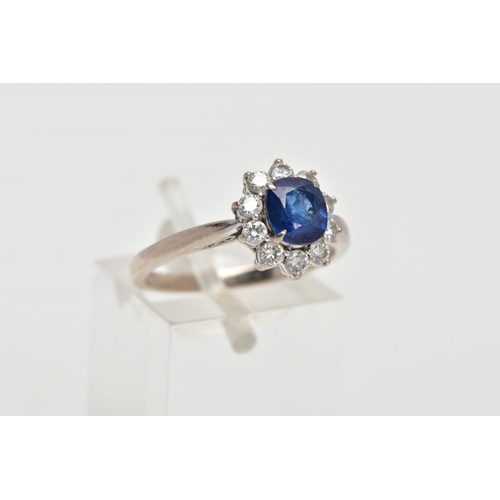 48 - A SAPPHIRE AND DIAMOND CLUSTER RING, centring on a four claw set, oval cut blue sapphire, within a s... 