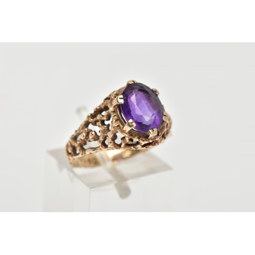 50 - AN AMETHYST DRESS RING, designed with a six claw set, oval cut amethyst, textured openwork detailed ... 