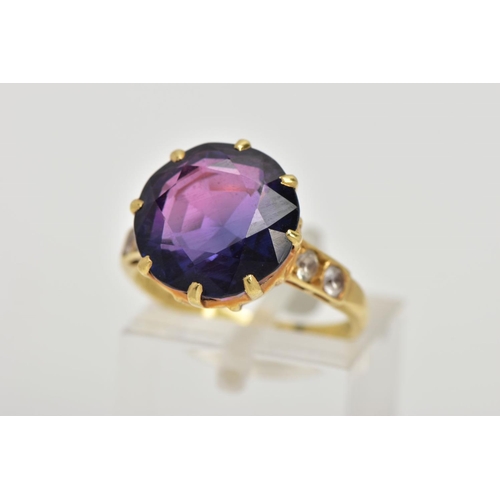 67 - A YELLOW METAL SYNTHETIC SAPPHIRE RING, designed with a circular cut synthetic colour change sapphir... 