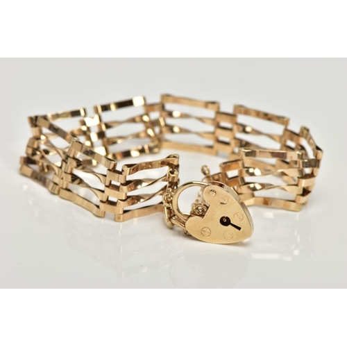 140 - A 9CT GOLD GATE BRACELET,  four bar polished yellow gold gate bracelet, fitted with a heart padlock ... 